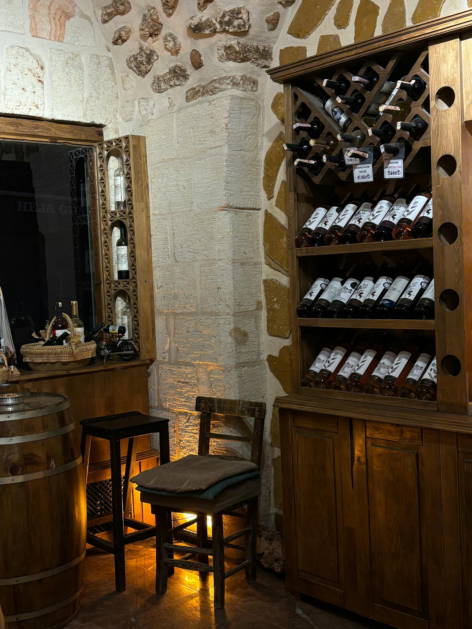 The original 1898 cellar — French oak barrels and a small wooden table set for two with candles.